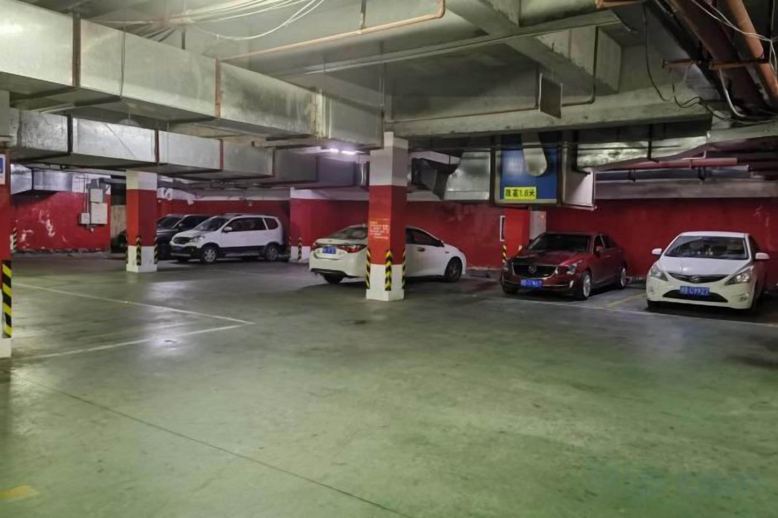 Un estacionamiento con varios niveles y varios coches aparcados.