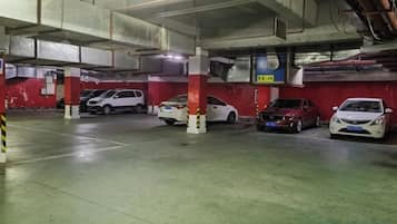 Un estacionamiento con varios niveles y varios coches aparcados.