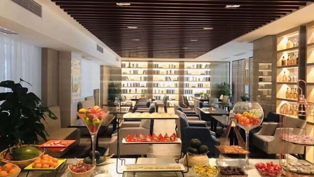 Un hall d’hôtel avec un buffet, un coin salon et une bibliothèque.
