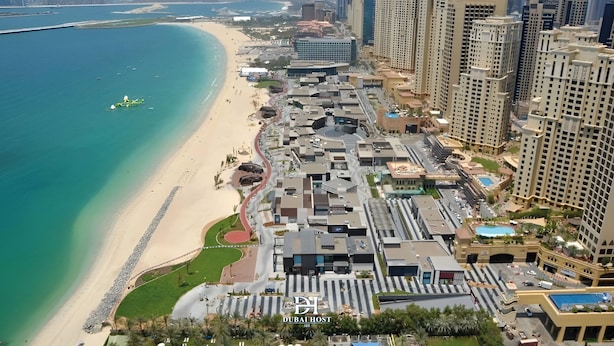 Eine Küstenstadt mit Hochhäusern, einem Strand und einem Yachthafen.