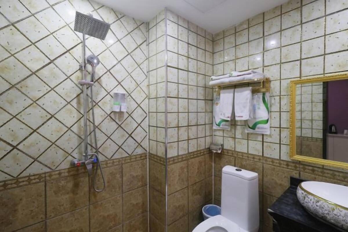A bathroom with a shower, toilet, and sink.
