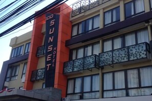 A building with a prominent vertical sign reading 'Sunset Hotel.' - 100 Sunset Kuta Hotel & Ballroom (Bali)