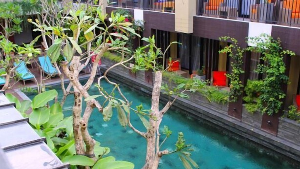 A pool area with clear water, surrounded by greenery and modern architecture. - 100 Sunset Kuta Hotel & Ballroom (Bali)