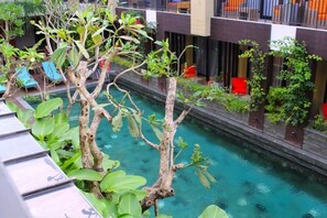 Un espace piscine avec une eau cristalline, entouré de verdure et agrémenté d’une architecture moderne.