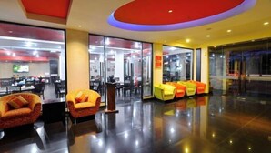 A modern lobby with a glass partition, a podium, and colorful seating areas. - 100 Sunset Kuta Hotel & Ballroom (Bali)