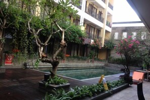 An indoor courtyard with a pool, potted plants, and a wooden deck. - 100 Sunset Kuta Hotel & Ballroom (Bali)
