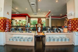 A buffet setup with multiple serving stations, a central display, and a seating area. - 100 Sunset Kuta Hotel & Ballroom (Bali)