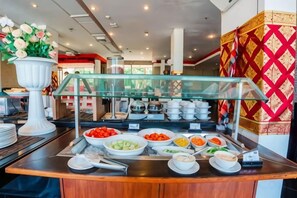 A buffet counter with various food items and a glass display case. - 100 Sunset Kuta Hotel & Ballroom (Bali)