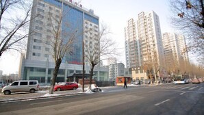 A multi-story building with a modern architectural design, featuring large windows and a mix of glass and concrete facades.