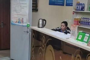 Mostrador de recepción con una tetera, documentos y un código QR.