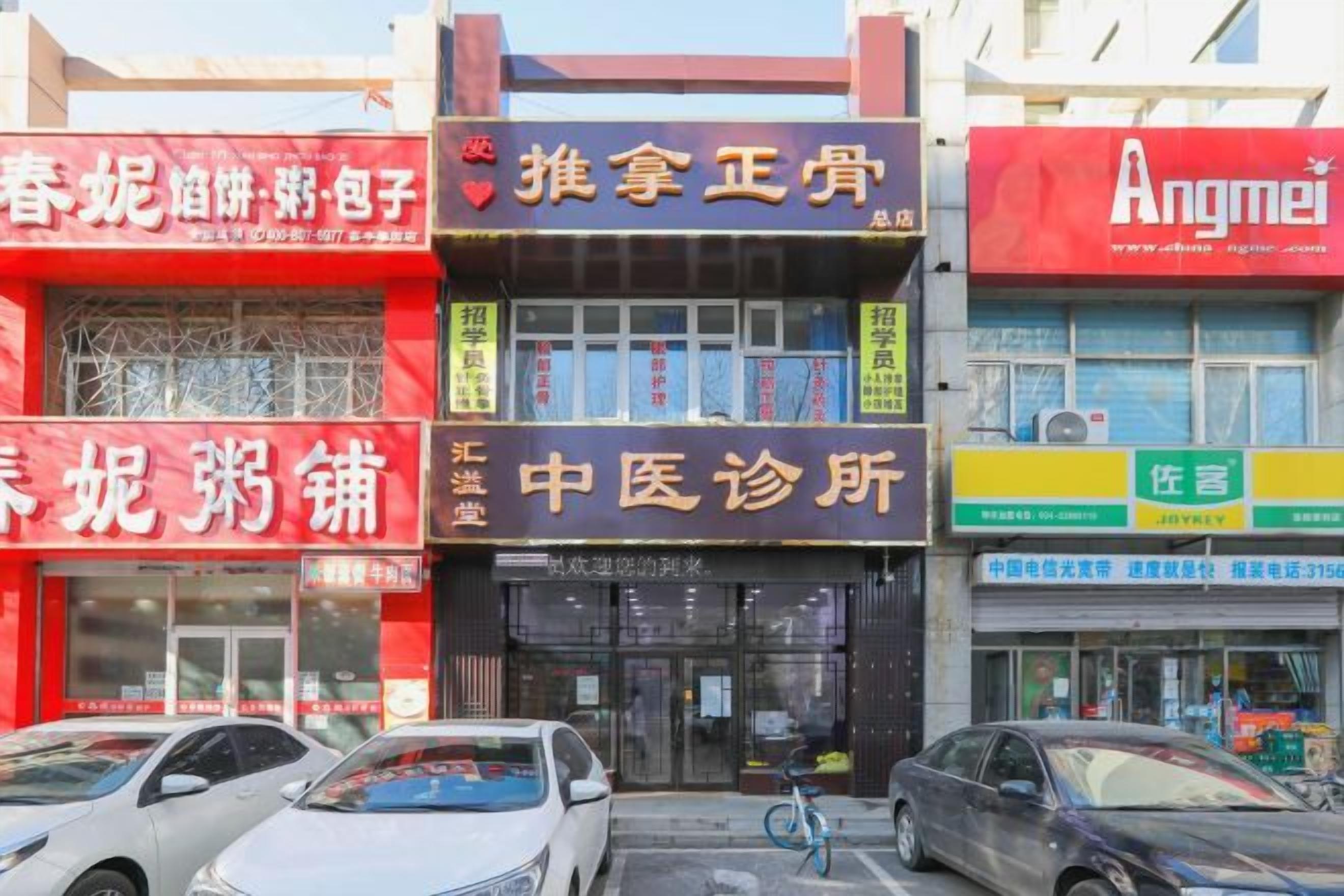 A row of commercial buildings with various storefronts, including a medical clinic and a travel agency.