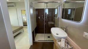 A modern bathroom with a glass-enclosed shower, a white sink, and a wooden vanity. - B&B Jerocades (Parghelia)