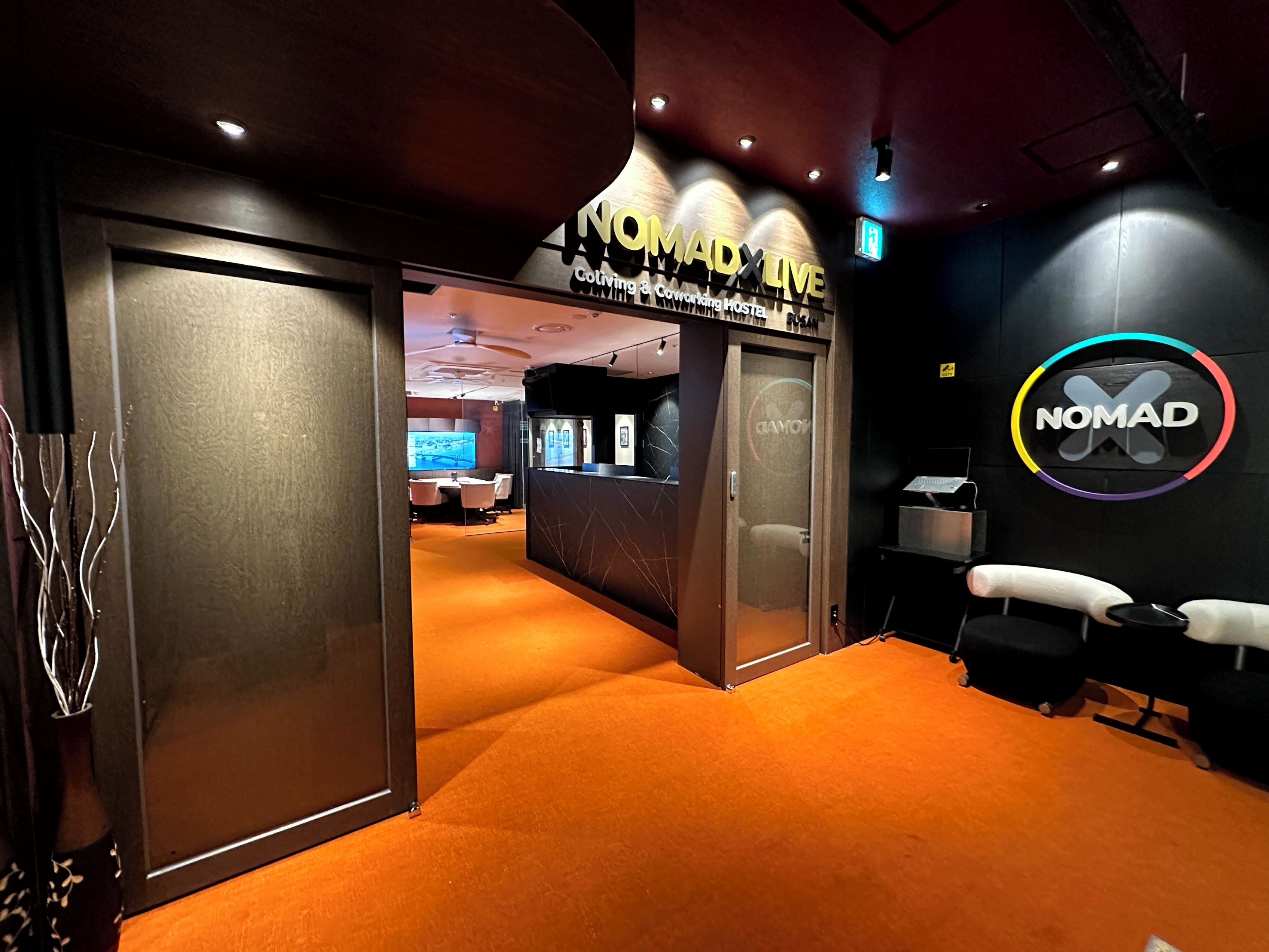 A hotel lobby with a reception desk, a conference area, and a restroom.