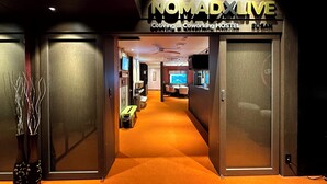 A modern hostel entrance with a sign reading "NOMADXLIVE".