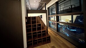 Ein modernes Interieur mit einer Holztreppe, einem großen Fenster mit Stadtlichtern und einem Deckenventilator.