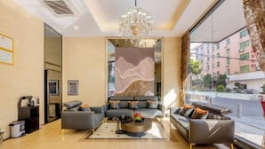 A modern living room with a sofa set, a coffee table, and a decorative wall panel. - Shengshi Hotel (Zengcheng Donghuicheng Wanda Store) (Guangzhou)