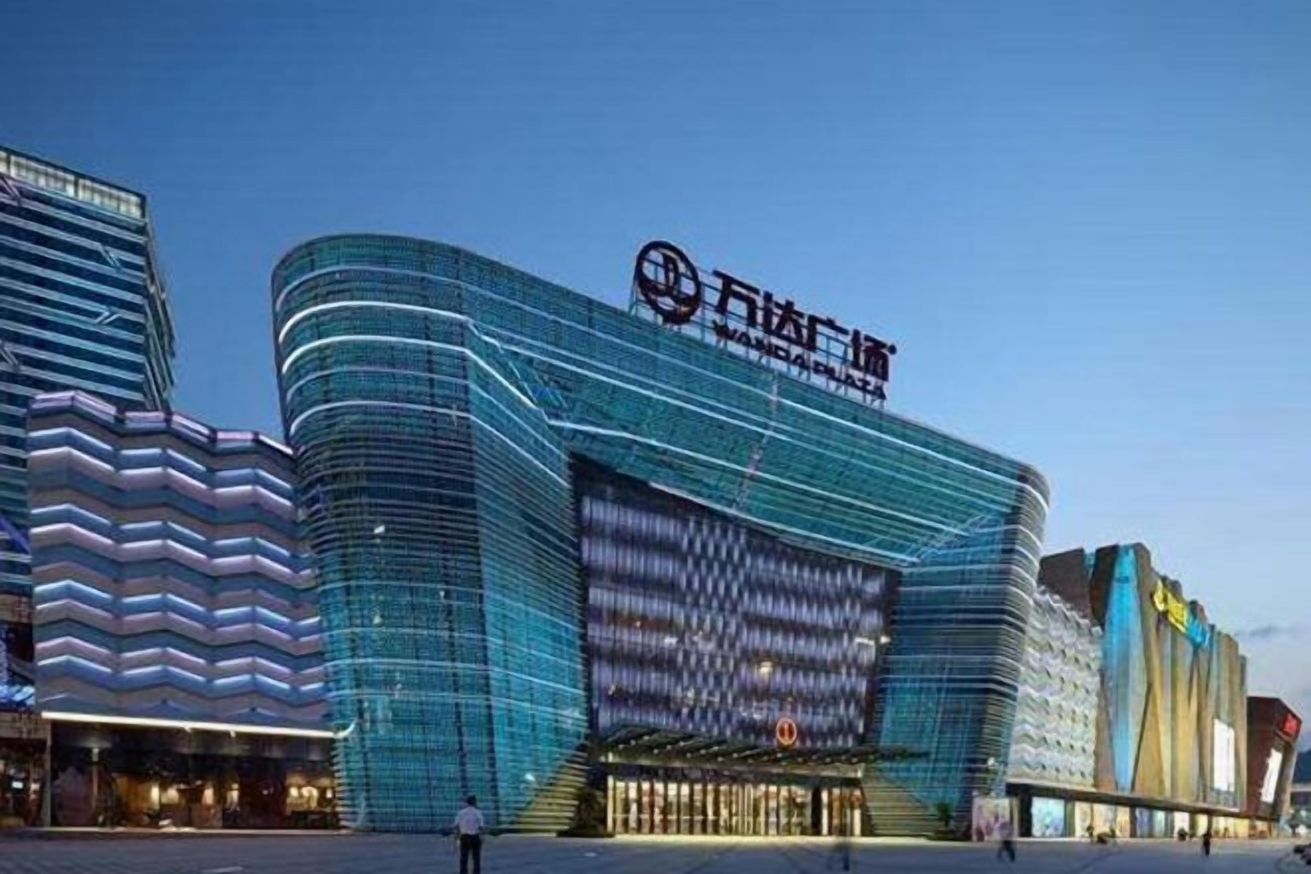 A modern building with a curved facade and a prominent sign.
