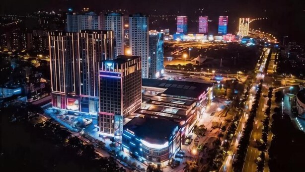 A high-rise building complex with multiple illuminated structures, likely a hotel or business center, surrounded by busy roads. - Shengshi Hotel (Zengcheng Donghuicheng Wanda Store) (Guangzhou)