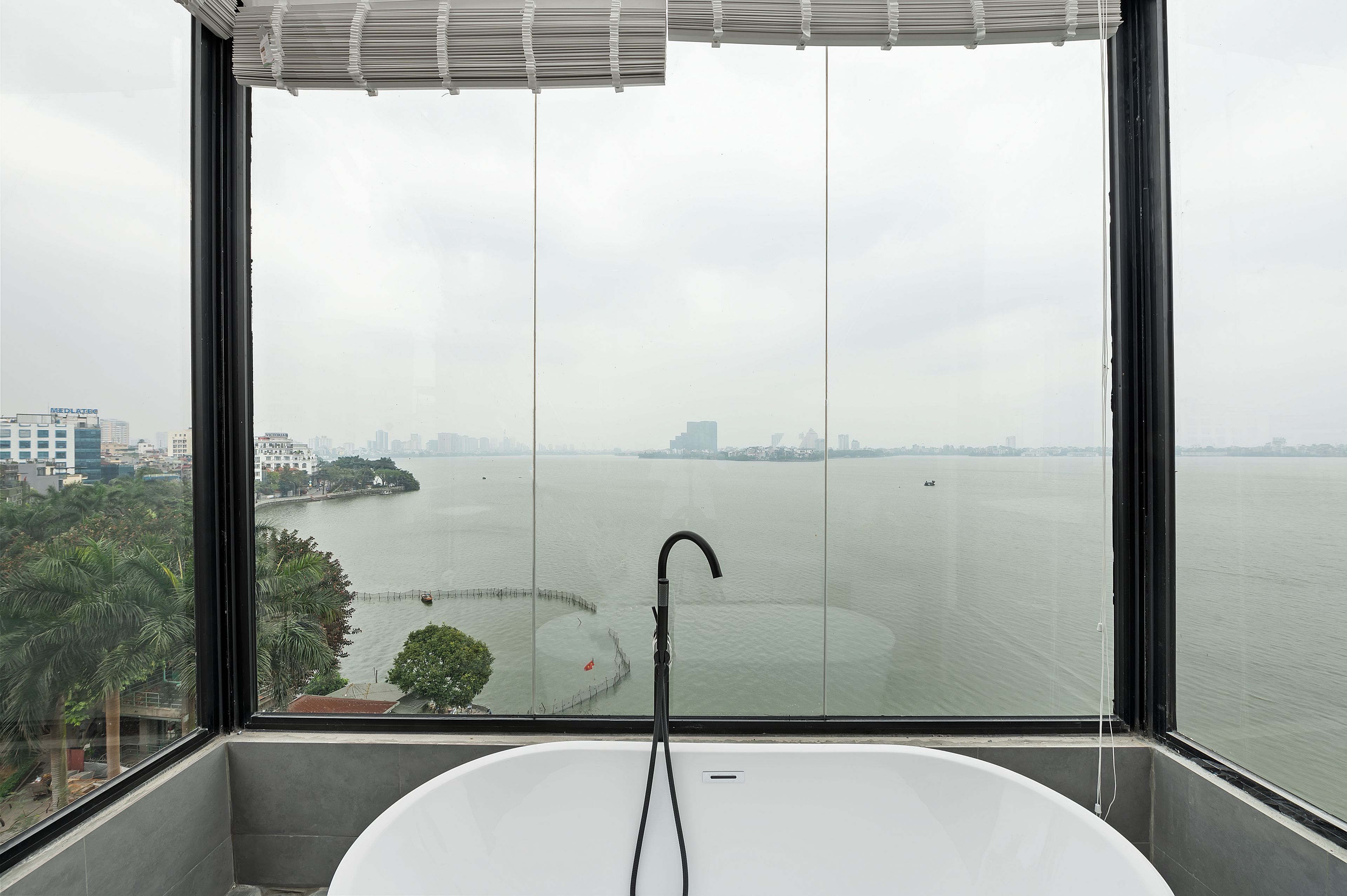 A bathroom with a bathtub and a view of a large body of water through a large window.
