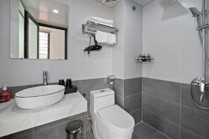 Une salle de bain moderne avec un grand lavabo blanc, des toilettes et une douche.