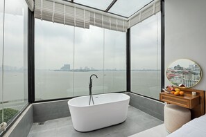 A modern bathroom with a freestanding bathtub, a wooden vanity, and a large mirror. - Lakeview Residence (Hanoi)