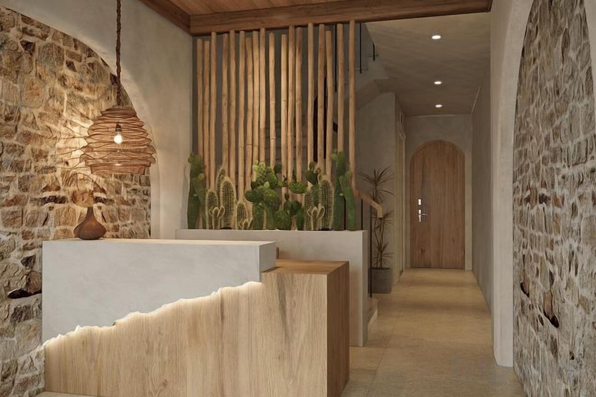A reception area with a stone wall, wooden reception desk, and a vertical bamboo panel.