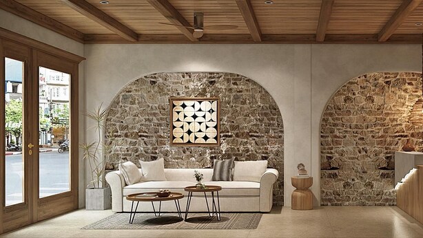 Un intérieur moderne avec un mur en pierre, un canapé blanc, une table basse et un luminaire suspendu.