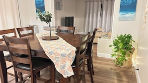 A dining area with a wooden table, chairs, and a patterned table runner.