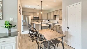 A modern kitchen with a central island, stainless steel appliances, and pendant lighting. - 3BD Houston Home: Fenced Yard & Minutes to Downtown Houston (Houston)