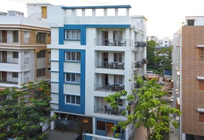 A multi-story residential building with balconies, a ground-level entrance, and a visible staircase. - Ostro Inn (Barasat)