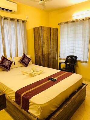 A hotel room with a large bed, wooden headboard, and curtains. - Ostro Inn (Barasat)