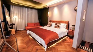 A modern hotel room with a large bed, a desk, a chair, and a lamp. - L.A.B. Hot Spring Guesthouse, Tangshan, Nanjing (Nanjing)