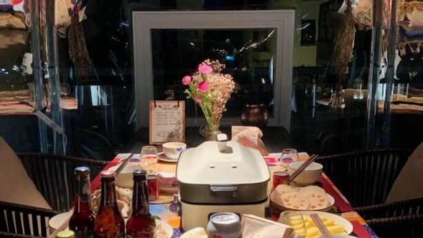 A dining table with various food items, bottles, and a rice cooker. - L.A.B. Hot Spring Guesthouse, Tangshan, Nanjing (Nanjing)