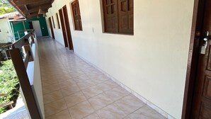 A corridor with tiled flooring, wooden doors, and a number '8' on the wall. - Pousada Boa Esperança Beach (Ipojuca)