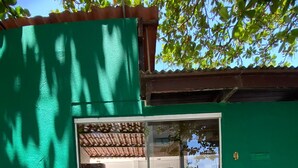 A building entrance with a green door, a tiled pathway, and a view of the interior through a glass door. - Pousada Boa Esperança Beach (Ipojuca)