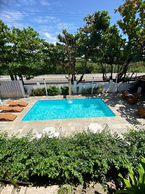 A rectangular swimming pool with clear blue water, surrounded by a paved deck. - Pousada Boa Esperança Beach (Ipojuca)