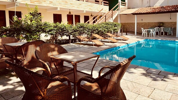 A poolside area with wicker furniture and a clear view of the pool. - Pousada Boa Esperança Beach (Ipojuca)