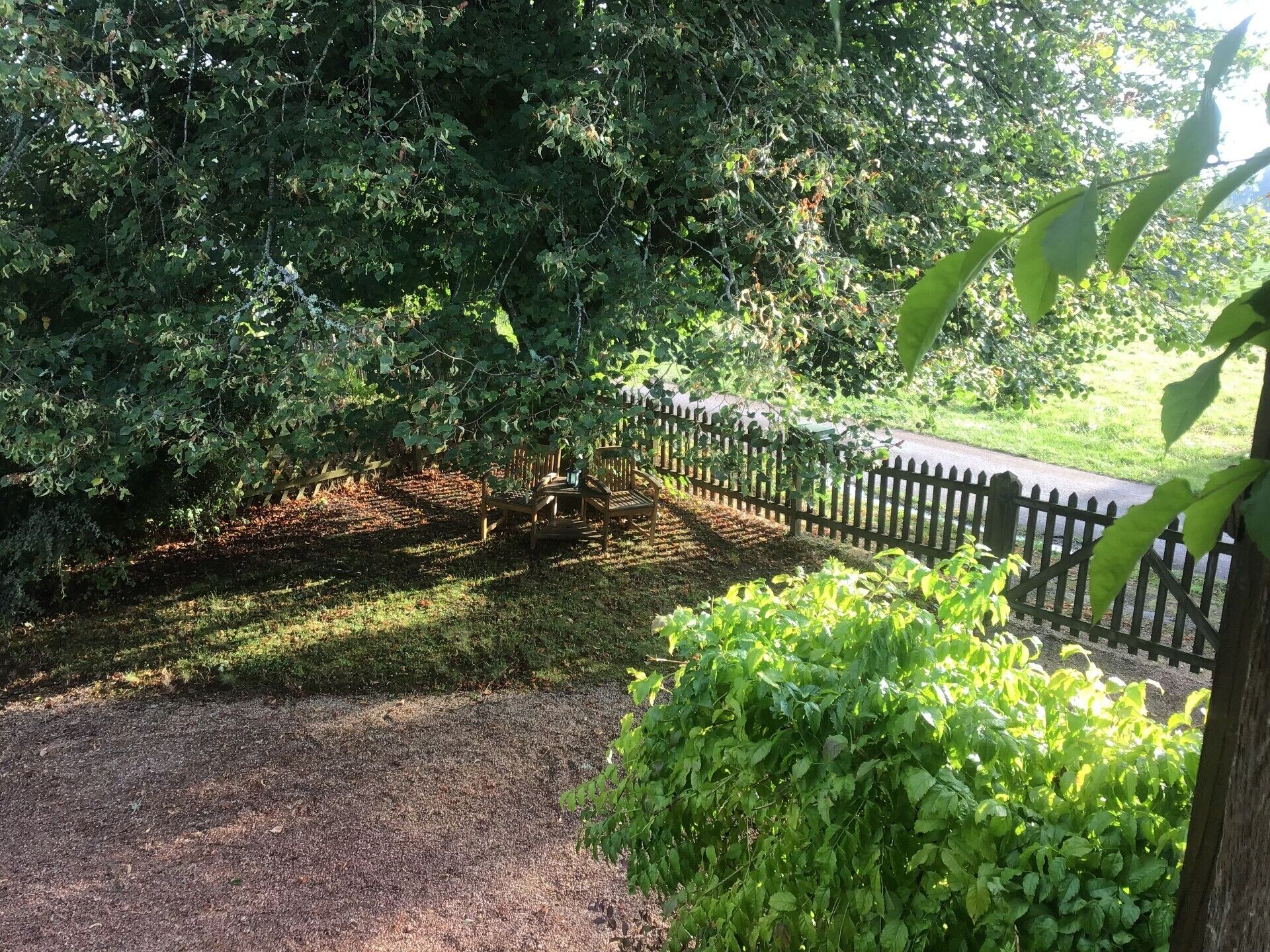 A garden area with a wooden fence, a table, and chairs.