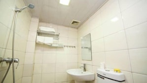 A small, clean bathroom with white tiles, a sink, a mirror, and a towel rack. - Fenghua Hotel (Yichang)