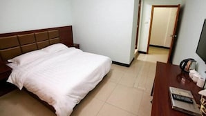 A hotel room with a bed, a wooden nightstand, a desk with a remote control, and a television. - Fenghua Hotel (Yichang)