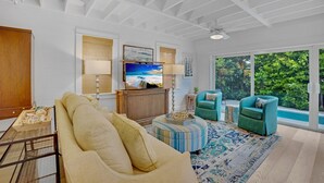 A modern living room with a large TV, comfortable seating, and a view of the outdoors. - **SOUTHERN STAR @ THE MEADOWS** Home & Pool + Last Key White Glove Service... (Key West)