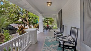 A covered porch with a white railing, outdoor furniture, and potted plants. - **SOUTHERN STAR @ THE MEADOWS** Home & Pool + Last Key White Glove Service... (Key West)