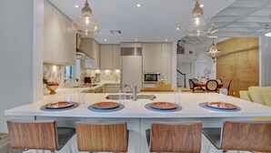 A modern kitchen with a central island, stainless steel appliances, and pendant lighting. - **SOUTHERN STAR @ THE MEADOWS** Home & Pool + Last Key White Glove Service... (Key West)