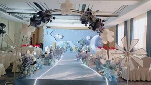 A hotel lobby with a central aisle decorated with floral arrangements and a chandelier. Tables are set up on either side of the aisle. - Kameidun Hotel (Changsha University of Science and Technology Yuntang Campus) (Changsha)