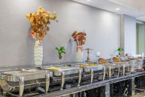 A buffet setup with various food containers and decorative vases on a marble countertop. - Kameidun Hotel (Changsha University of Science and Technology Yuntang Campus) (Changsha)