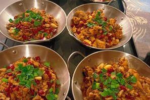 Four stainless steel pans on a stove with stir-fried food, garnished with green onions. - Kameidun Hotel (Changsha University of Science and Technology Yuntang Campus) (Changsha)