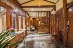A traditional interior with wooden doors and a tiled floor. - Yunmengze Hostel (Lijiang)
