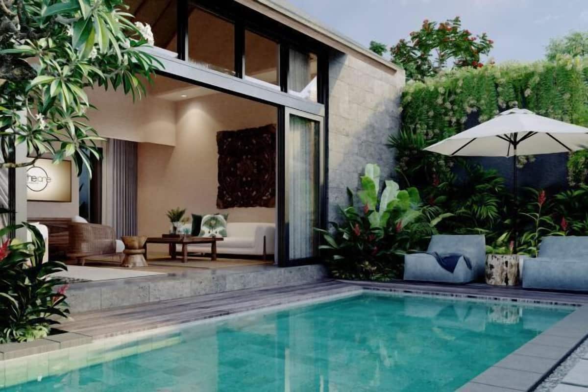 A modern outdoor pool area with a seating area, a lounge chair, and a large umbrella.