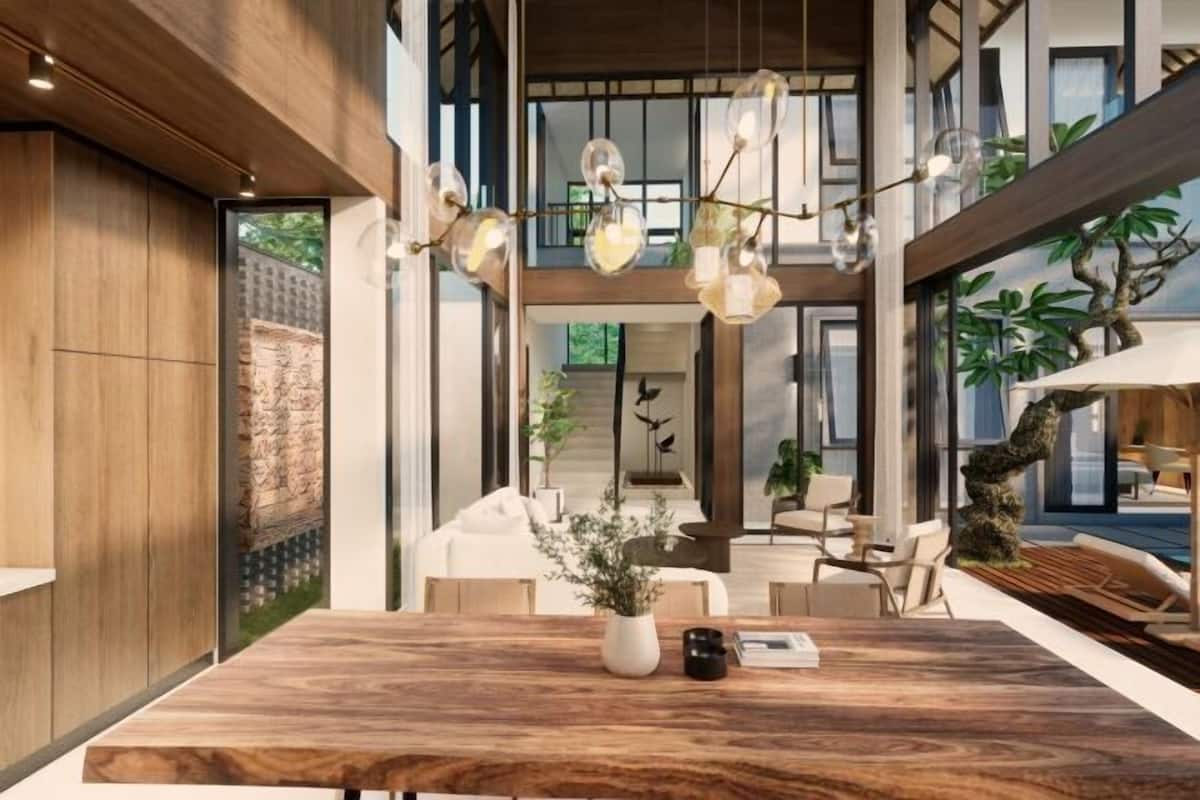 A spacious dining area with a large wooden table, hanging pendant lights, and a view of the outdoor terrace.