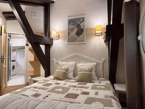 Ein Schlafzimmer mit einem Bett, zwei Wandlampen, einem Poster und einer Treppe.